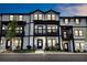 Charming townhome exterior with balconies, black trim, and inviting entrance, in a vibrant community at 1104 Knoxboro Ln, Woodstock, GA 30188