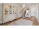 Inviting home entry featuring hardwood floors, elegant cabinet, and staircase with runner at 1104 Knoxboro Ln, Woodstock, GA 30188
