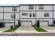 View of three townhome garages with white doors and dark trim in a well-maintained community at 1104 Knoxboro Ln, Woodstock, GA 30188