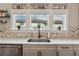 Modern kitchen features a decorative tile backsplash, a stainless sink and a window at 1104 Knoxboro Ln, Woodstock, GA 30188