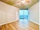 Bright bedroom features wood floors, concrete ceiling, fan, and city views through a large window at 400 W Peachtree Nw St # 2704, Atlanta, GA 30308