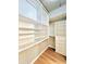 Spacious walk-in closet with built-in shelving, drawers, and hardwood floors at 400 W Peachtree Nw St # 2704, Atlanta, GA 30308