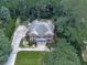 An aerial view of the brick home featuring mature trees, landscaping and a long driveway at 4450 Barony Dr, Suwanee, GA 30024