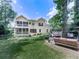 Large backyard with mature trees, manicured lawn and deck on the back of the house at 4450 Barony Dr, Suwanee, GA 30024
