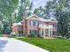 Traditional brick home with a lush front yard, long driveway, side garage and mature shade trees at 4450 Barony Dr, Suwanee, GA 30024