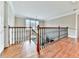 Upstairs hallway with hardwood floors and decorative wrought iron railing at 4450 Barony Dr, Suwanee, GA 30024