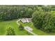 Aerial view of a well-maintained home with a pool, surrounded by lush greenery and a long driveway at 5095 Karr Road Rd, Cumming, GA 30040