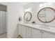 Bathroom featuring marble countertops, planked wall, and dual vintage-style mirrors over the sinks at 5095 Karr Road Rd, Cumming, GA 30040