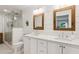 Bright bathroom with a glass-door shower and dual sinks with framed mirrors and planked accent wall at 5095 Karr Road Rd, Cumming, GA 30040