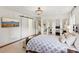 Bright bedroom with white-paneled walls, barn door, and mirrored closet reflecting the patterned bedspread at 5095 Karr Road Rd, Cumming, GA 30040