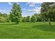 Spacious front yard featuring lush green grass and mature trees, perfect for outdoor activities at 5095 Karr Road Rd, Cumming, GA 30040