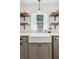 Bright kitchen with open shelving, white countertops, a farmhouse sink, and a view of the outdoors at 5095 Karr Road Rd, Cumming, GA 30040