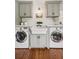 Laundry room with custom cabinets, white countertop, farmhouse sink and stainless steel washer/dryer at 5095 Karr Road Rd, Cumming, GA 30040