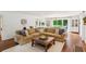 Bright living room with hardwood floors, a large sectional sofa, and view into dining area at 5095 Karr Road Rd, Cumming, GA 30040