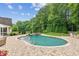 Beautiful in-ground pool surrounded by an extensive stone patio and lush landscaping at 5095 Karr Road Rd, Cumming, GA 30040