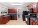 Well-equipped kitchen with dark wood cabinetry, black appliances, and tiled backsplash; ready for culinary adventures at 5865 El Segundo Way, Atlanta, GA 30349