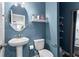Charming blue bathroom with pedestal sink, oval mirror, and toilet at 113 Poppy St, Mcdonough, GA 30253