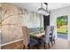Dining room with a unique wood table and artistic wall design leading to backyard at 113 Poppy St, Mcdonough, GA 30253