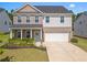 Charming two-story home featuring a brick and siding exterior, manicured lawn, and attached two-car garage at 113 Poppy St, Mcdonough, GA 30253
