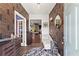 Elegant foyer showcasing decorative wallpaper, hardwood floors, stylish furnishings, and an inviting ambiance at 113 Poppy St, Mcdonough, GA 30253