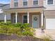 Inviting front porch with brick facade, white columns, and a vibrant wreath adorning the blue front door at 113 Poppy St, Mcdonough, GA 30253