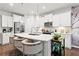 Modern kitchen with white cabinetry, stainless steel appliances, a center island with seating, and hardwood flooring at 113 Poppy St, Mcdonough, GA 30253