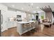 Modern kitchen featuring white cabinets, stainless steel appliances, a spacious island with seating, and hardwood floors at 113 Poppy St, Mcdonough, GA 30253