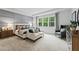 Beautiful primary bedroom with a sitting area, large window, and soft carpet, creating a relaxing retreat at 817 Dobby Way, Mcdonough, GA 30252