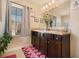 Modern bathroom with double sink vanity, decorative plant, and natural light from the window at 8484 Glenview St, Douglasville, GA 30134