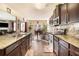 Open-concept kitchen with granite countertops, stainless steel appliances, and dark wood cabinets at 8484 Glenview St, Douglasville, GA 30134