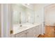 Bright bathroom with a dual sink vanity, white cabinets, and an expansive mirror at 205 Finsbury Park Ct, Suwanee, GA 30024