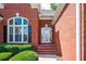 Close-up of the beautiful red brick front entrance with decorative shrubbery at 205 Finsbury Park Ct, Suwanee, GA 30024