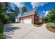 Spacious two-car garage with a long driveway and mature trees providing ample shade at 205 Finsbury Park Ct, Suwanee, GA 30024