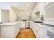 Well-lit kitchen featuring white cabinets, stainless steel appliances, an island, and an arched window at 205 Finsbury Park Ct, Suwanee, GA 30024