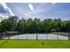 Community tennis court surrounded by lush greenery and fencing, offering a private and enjoyable playing experience at 205 Finsbury Park Ct, Suwanee, GA 30024