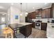 Kitchen features stainless steel appliances, granite countertops, dark wood cabinets and kitchen island with seating at 2277 Church St, Hampton, GA 30228