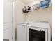 Bright laundry room featuring modern washer and dryer units and shelving for storage at 2277 Church St, Hampton, GA 30228