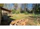 Lush backyard featuring a covered deck, providing an ideal outdoor living space surrounded by mature trees and natural landscaping at 494 Rue Montaigne, Stone Mountain, GA 30083