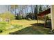 Spacious backyard with a covered deck, mature trees, and a level grassy area, perfect for outdoor activities and relaxation at 494 Rue Montaigne, Stone Mountain, GA 30083