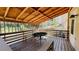 Covered wooden deck with a table and bench seating, perfect for outdoor entertaining and relaxation in the shade at 494 Rue Montaigne, Stone Mountain, GA 30083
