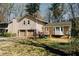 View of home with attached garage on large lot surrounded by mature trees and shade at 494 Rue Montaigne, Stone Mountain, GA 30083