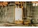 Efficient Bosch water heater with modern plumbing, installed on a gray brick wall within an unfinished space, plus bag of Quikrete at 494 Rue Montaigne, Stone Mountain, GA 30083