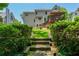 Green backyard with mossy wooden steps and well-manicured hedges and green grass at 545 Ashvale Overlook, Alpharetta, GA 30005