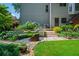 Lovely backyard featuring a bench, stone pathway, raised flower beds and a lush lawn at 545 Ashvale Overlook, Alpharetta, GA 30005