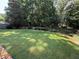 Spacious backyard featuring a well-maintained lawn and mature trees for privacy at 545 Ashvale Overlook, Alpharetta, GA 30005