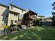 View of the home's exterior showing a large deck and a lush green backyard at 545 Ashvale Overlook, Alpharetta, GA 30005
