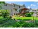 Well-manicured backyard featuring a covered deck, lush lawn and mature trees at 545 Ashvale Overlook, Alpharetta, GA 30005