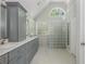 Well-lit bathroom with double vanity, white marble counters, and a glass block shower wall at 545 Ashvale Overlook, Alpharetta, GA 30005