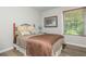 Cozy bedroom with warm hues and natural light from the window at 545 Ashvale Overlook, Alpharetta, GA 30005