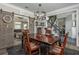 Dining area featuring sliding barn doors, an elegant chandelier, and easy access to the staircase at 545 Ashvale Overlook, Alpharetta, GA 30005